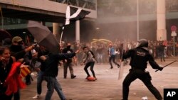 Polisi anti huru-hara bentrok dengan para pemrotes di luar bandara El Prat di Barcelona, Spanyol, Senin, 14 Oktober 2019. Mahkamah Agung menghukum 12 separatis terkemuka Catalan dengan hukuman penjara yang panjang atas desakan referendum pada 2017. (Foto: AP/Emil Morenatti)