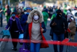 FILE - Residents of the Iztacalco borough follow a long, snaking line to receive doses of the Russian COVID-19 vaccine Sputnik V, during a mass vaccination campaign for Mexicans over age 60, in Mexico City, Feb. 24, 2021.