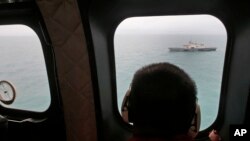 A military ship is seen from Indonesian Air Force NAS 332 Super Puma helicopter during a search operation for the victims of AirAsia Flight 8501, off Pangkalan Bun, Central Borneo, Indonesia, Jan. 6, 2015.