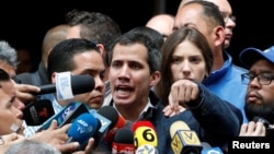 Venezuelan opposition leader and self-proclaimed interim president Juan Guaido, accompanied by his wife Fabiana Rosales, speaks to the media after a church service in Caracas, Venezuela, Jan. 27, 2019.