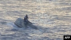 Gambar yang diambil pada 25 Januari 2022 ini menunjukkan sebuah perahu terbalik yang berada sekitar 72,4 kilometer dari Fort Pierce, Florida. Perahu tersebut diduga membawa kelompok migran dari Bahama. (Foto: US Coast Guard via AFP)