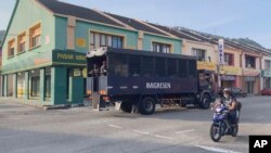23일 말레이시아 루무트 해군기지에서 이민자들을 태운 트럭이 나오고 있다.