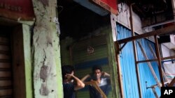 A man uses a mirror to put on a face mask at a market closed due to the coronavirus outbreak in Jakarta, Indonesia, April 10, 2020.