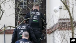 Polisi Jerman melakukan penggerebekan sebuah apartemen di Berlin, 18 Maret 2020.
