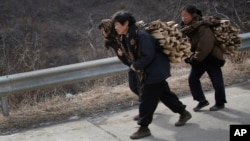North Korean women carry firewood as they walk along a highway in Sinpyong county in North Hwanghae province, North Korea. There are concerns that new sanctions will hurt ordinary North Koreans.