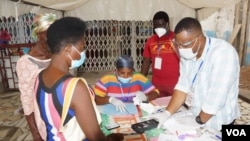 A voter waits for his ID to be checked before casting his ballot on election day in Accra, Ghana, Dec. 7, 2020. (Photo: Peter Clottey, Issah Ali / VOA)