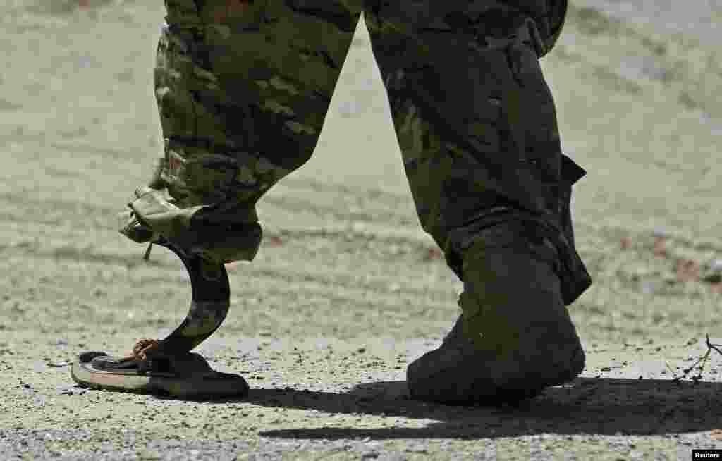 Seorang tentara NATO berjalan dengan kaki palsu menuju helikopter, setelah upacara serah terima keamanan dari pasukan NATO kepada pasukan Afghanistan di luar ibukota Kabul.