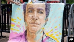 Un portrait de Marc Fogel qui était détenu en Russie depuis août 2021, accroché sur des barrières à l'extérieur de la Maison Blanche lors d'une manifestation organisée par sa famille, 15 juillet 2023. AP / Stephanie Scarbrough
