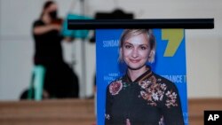 A musician plays a violin behind a photograph of cinematographer Halyna Hutchins during a vigil in her honor in Albuquerque, N.M., Saturday, Oct. 23, 2021. Hutchins was fatally shot on Thursday, Oct. 21, on a movie set in New Mexico.