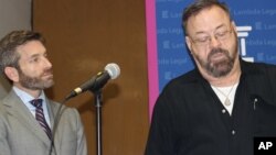 FILE - John East, left, and attorney Scott Schoettes discuss a lawsuit that the advocacy group Lambda Legal filed, Feb. 20, 2014, against three Louisiana insurance companies. Schoettes resigned in protest in June from the Presidential Advisory Council on HIV/AIDS.