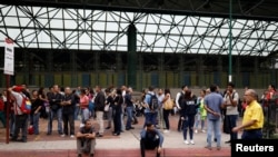 Para pengguna transportasi menunggu di luar stasiun kereta metro saat aliran listrik padam di Caracas, Venezuela, 22 Juli 2019. 