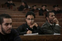 FILE - Mahinour el-Masry, an Egyptian activist, takes notes during a trial session of activists facing charges on organizing unauthorized protests, at a courtroom in Cairo, Egypt, Dec. 4, 2014..
