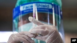 A health worker prepares a dose of the Sinovac COVID-19 vaccine for people who live in a popular market area where a new cluster of COVID-19 infections was found in Bangkok, Thailand, March 17, 2021. 