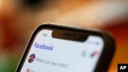 FILE - An iPhone displays a Facebook page, Aug. 11, 2019.