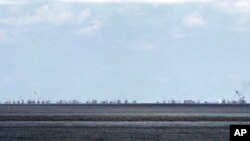 FILE - The alleged on-going reclamation of Subi Reef by China is seen from Pag-asa Island in the Spratly Islands in the South China Sea, western Palawan Province, Philippines, May 11, 2015.