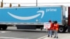 People hold a banner at the Amazon facility as members of a congressional delegation arrive to show their support for workers who will vote on whether to unionize, in Bessemer, Alabama, March 5, 2021. 