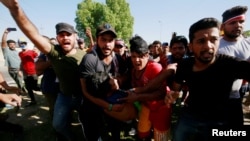 4일 이라크 수도 바그다드에서 반정부 시위가 계속 이어지는 가운데 시위대가 부상한 시위 참가자를 이동시키고 있다.