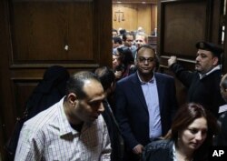 Investigative journalist Hossam Baghat, center, leaves a courtroom at the Cairo Criminal Court after the court postponed a decision on whether to implement an order to freeze his assets over allegations of illegal foreign funding, in Cairo, Egypt, March 24, 2016.