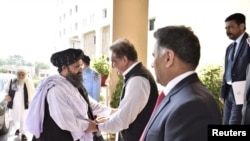 Menlu Pakistan, Shah Mehmood Qureshi menyambut baik Mullah Abdul Ghani Baradar, yang merupakan delegasi terkemuka Taliban, setibanya di Kementerian Luar Negeri, Islamabad, Pakistan, 3 Oktober 2019.