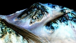 This undated photo provided by NASA and taken by an instrument aboard the agency's Mars Reconnaissance Orbiter shows dark, narrow, 100 meter-long streaks on the surface of Mars that scientists believe were caused by flowing streams of salty water. (NASA/J