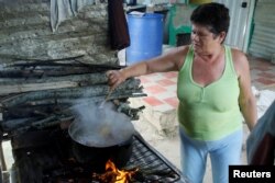 Margarita Rojas memasak dengan kayu bakar di rumahnya di San Cristobal, Venezuela, 5 Agustus 2017