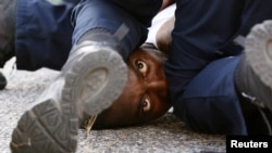 A man protesting the shooting death of Alton Sterling is detained by law enforcement near the headquarters of the Baton Rouge Police Department in Baton Rouge, Louisiana, July 9, 2016. 