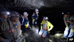 FILE - In this Jan. 13, 2015 file photo, Joe Main, third from left, Assistant Secretary of Labor for Mine Safety and Health, and Patricia Silvey, center, Deputy Assistant Secretary for Operations with MSHA, speak with workers at the Gibson North mine, in Princeton, Indiana. 