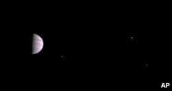 This July 10, 2016, image released by NASA was taken by the Juno spacecraft, five days after it arrived at Jupiter. The image shows Jupiter's Great Red Spot and three of its four largest moons.