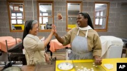 Poor Clares nuns Sister Maria Eden, left, and Sister Thereza share a laugh as they make altar bread also known as communion wafers, Sept. 8, 2015, at the Monastery of Saint Clare in Langhorne, Pa.