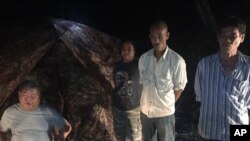 Pada bulan Februari ini 4, 2018, foto yang dikeluarkan oleh Departemen Taman Nasional Thailand, tokoh perusahaan konstruksi terbesar Thailand Premchai Karnasuta (kiri), terlihat di tempat terpisah di Suaka Margasatwa Thungyai Naresuan, provinsi Kanchanburi di perbatasan barat Thailand. Premchai, presiden Pembangunan Italia-Thailand, telah ditangkap karena melakukan pelanggaran dan perburuan.