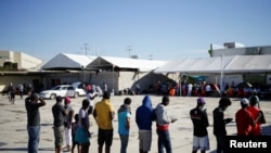 Migrants from Haiti, who returned to the Mexican side of the border to avoid deportation, queue for breakfast at a shelter set by the National Migration Institute (INM) in Ciudad Acuna, Sept. 25, 2021. 