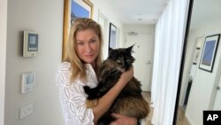มาร์โก นีส์ อุ้มแมวมิทเทนส์ ที่บ้านในเมลเบิร์น ออสเตรเลีย 22 ม.ค. 2025 (AP Photo/Rod McGuirk)