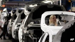 Para pekerja mengerjakan mobil Ford Fiesta di pabrik mobil Ford di Cologne, Jerman. (Foto: dok. AP Photo/Frank Augstein)