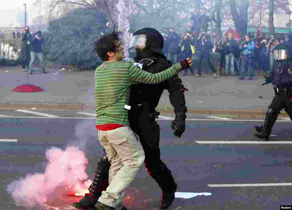 A policeman stops a &#39;Blockupy&#39; anti-capitalist protester near the European Central Bank (ECB) building before the official opening of its new headquarters in Frankfurt, Germany.