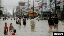 People walk in a flooded street at Muang district in Nakhon Si Thammarat Province, southern Thailand, Jan. 6, 2017. 