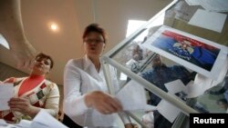 Para anggota komisi pemilu lokal mengosongkan kotak suara untuk menghitung suara dalam referendum untuk status wilayah Donetsk di Ukraina Timur (11/5). 