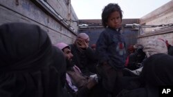Seorang anak berdiri di bak belakang truk setelah diungsikan dari kantong pertahanan terakhir militan Islamic State, di luar Baghouz, Suriah, Senin, 4 Maret 2019 (foto: AP Photo/Andrea Rosa)