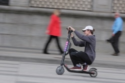 FILE - A man rides a Lyft Scooter near the White House in Washington, March 29, 2019.