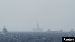 FILE - Ships and an oil rig, center, which China calls Haiyang Shiyou 981, and Vietnam refers to as Hai Duong 981, is seen in the South China Sea, off the shore of Vietnam, May 14, 2014.