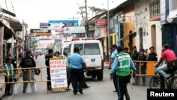 An ambulance passes a police checkpoint to evacuate people from the San Miguel church, where mothers of political prisoners were on a hunger strike for nine days to demand the release of their sons and daughters, in Masaya, Nicaragua, Nov. 22, 2019.
