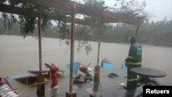A person looks at flood waters following a hit of the tropical cyclone Kompasu in Baguio, Philippines, October 12, 2021.