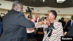 Le premier vice-président du Soudan du Sud, Riek Machar, utilise son coude pour saluer sa femme nommée ministre de la défense, Angelina Teny, avant la cérémonie de prestation de serment à Juba, au Sud-Soudan, le 16 mars 2020. (Photo: REUTERS/Jok Solomun)