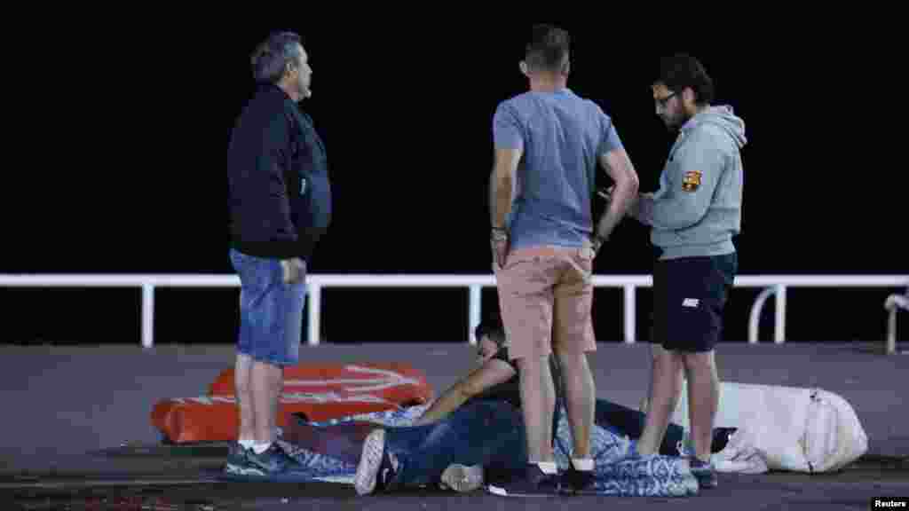 Une personne blessée, assise au sol, est assistée par des passants après l&#39;attaque de Nice, France, 14 juillet 2016. 