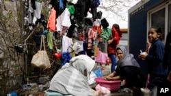 ស្រ្តី​ជន​ជាតិ​អាហ្វហ្គានីស្ថាន​បោក​សម្លៀក​បំពាក់​នៅ​​ទីក្រុង​ Piraeus ក្បែរ​ក្រុង​អាថែន​ ប្រទេស​ក្រិក​ ថ្ងៃ​ទី​៨​ ខែ​មិនា​ ឆ្នាំ​២០១៦។​