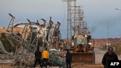 รถบูลโดเซอร์ขณะนำซากปรักหักพังออกจากถนนหลัก ทางตอนเหนือของนูเซรัต ฉนวนกาซ่า วันที่ 19 ม.ค. 2025 (ที่มา: AFP)