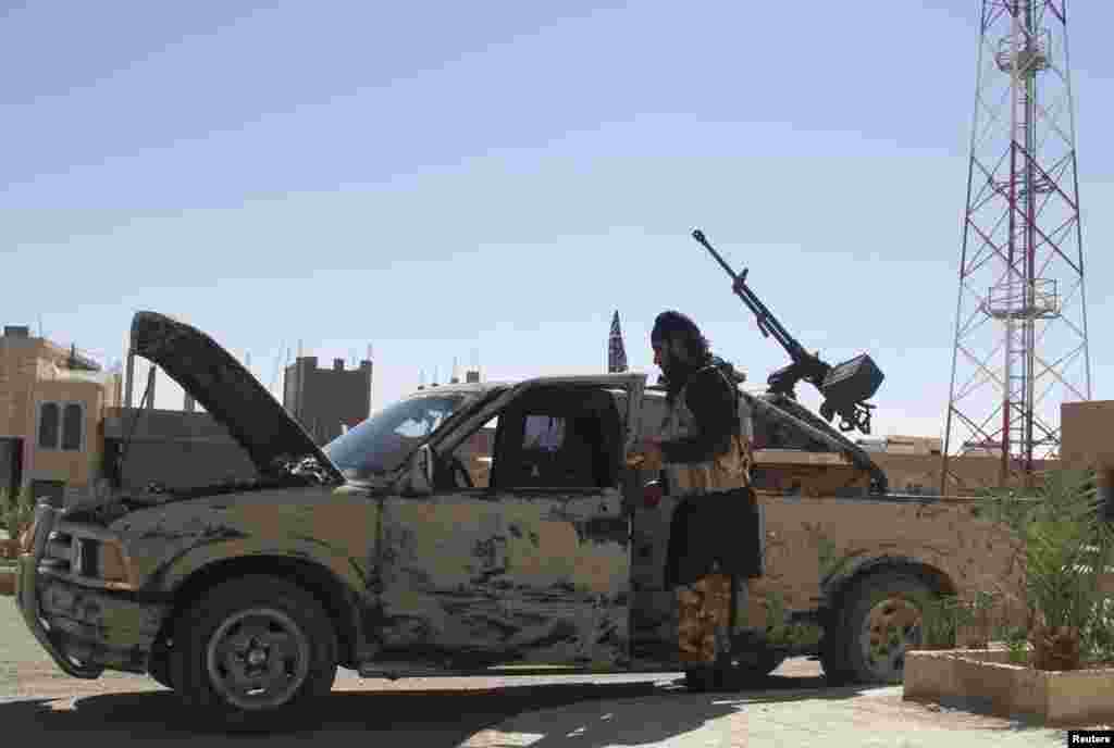 A Free Syrian Army fighter is seen near a vehicle mounted with an anti-aircraft weapon in Al-Sukhna in Homs province, Oct. 20, 2013.