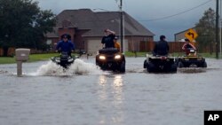 29일 열대성 폭풍 '하비'가 내린 비로 침수된 루이지애나주 레이크찰스 주택가 도로에서 청소년들이 오프로드용 4륜차를 이용해 이동하고 있다.