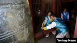 15일 평양시 중심부인 중구역 대동문의 연광정에서 청색 저고리에 흰색 한복 바지를 입은 남성 2명이 '평양시'를 알리는 타종을 하고 있다고 조선중앙통신이 보도했다. 