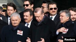 Le Premier ministre Binali Yildirim, le président Tayyip Erdogan et l'ancien président Abdullah Gul prient lors d'une cérémonie en hommage aux victimes du double attentat à Istanbul, le 11 décembre 2016. 