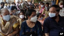 People wait to receive vaccine for COVID-19 outside a vaccination center in Mumbai, India, May 13, 2021. 